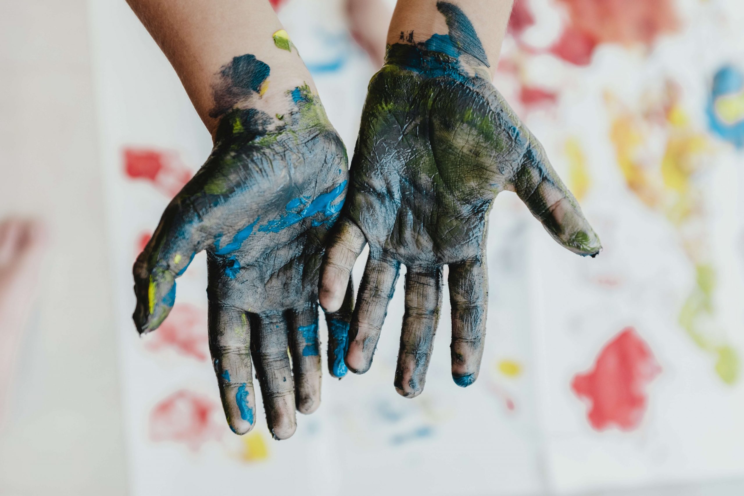 hands covered in messy paint