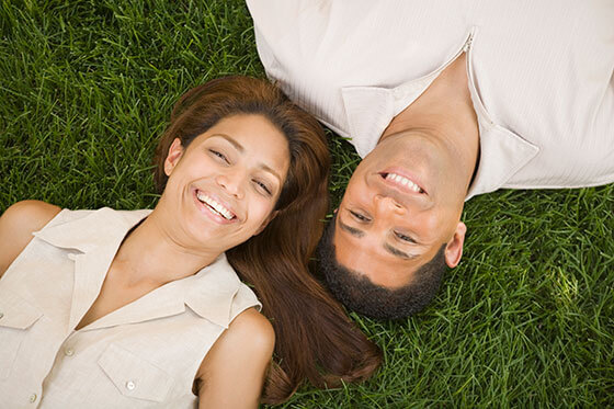 couple laying on green grass